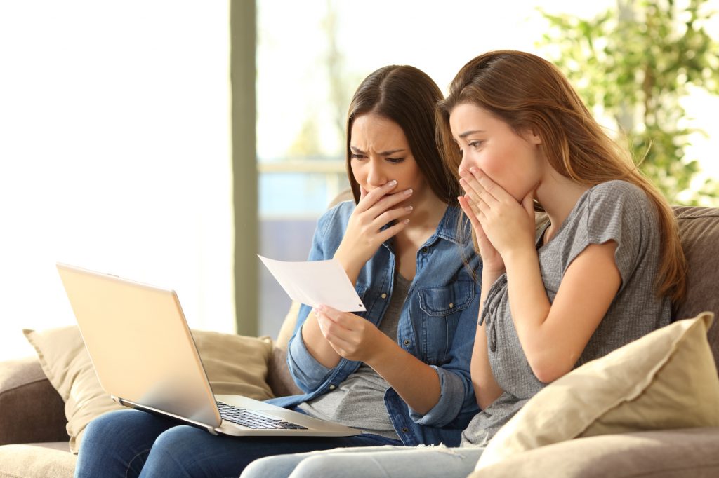 Worried roommates reading a bank notification