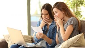 Worried roommates reading a bank notification