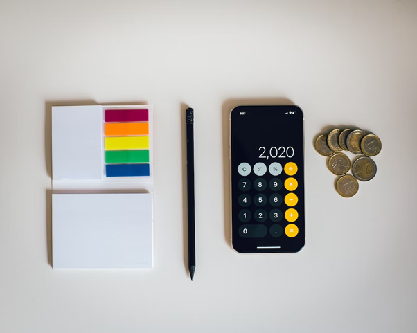 Sticky note. calculator and coins 