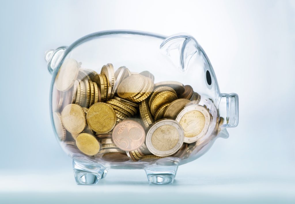 A see through piggy bank with money coins