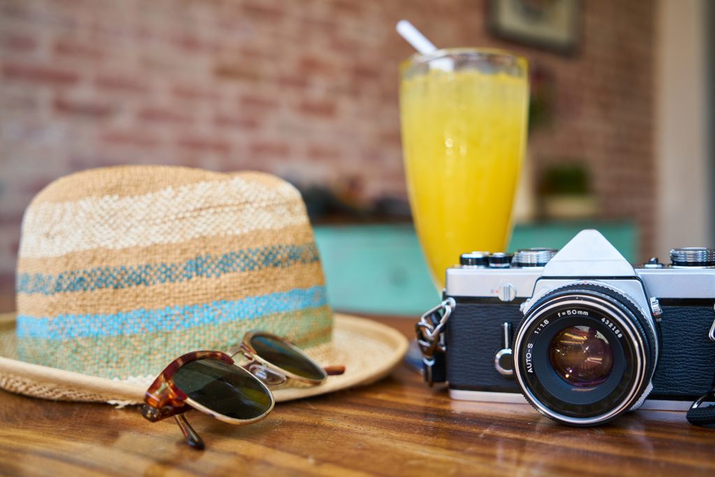 cocktail hat camera and sunglasses on table