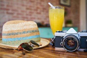 cocktail hat camera and sunglasses on table